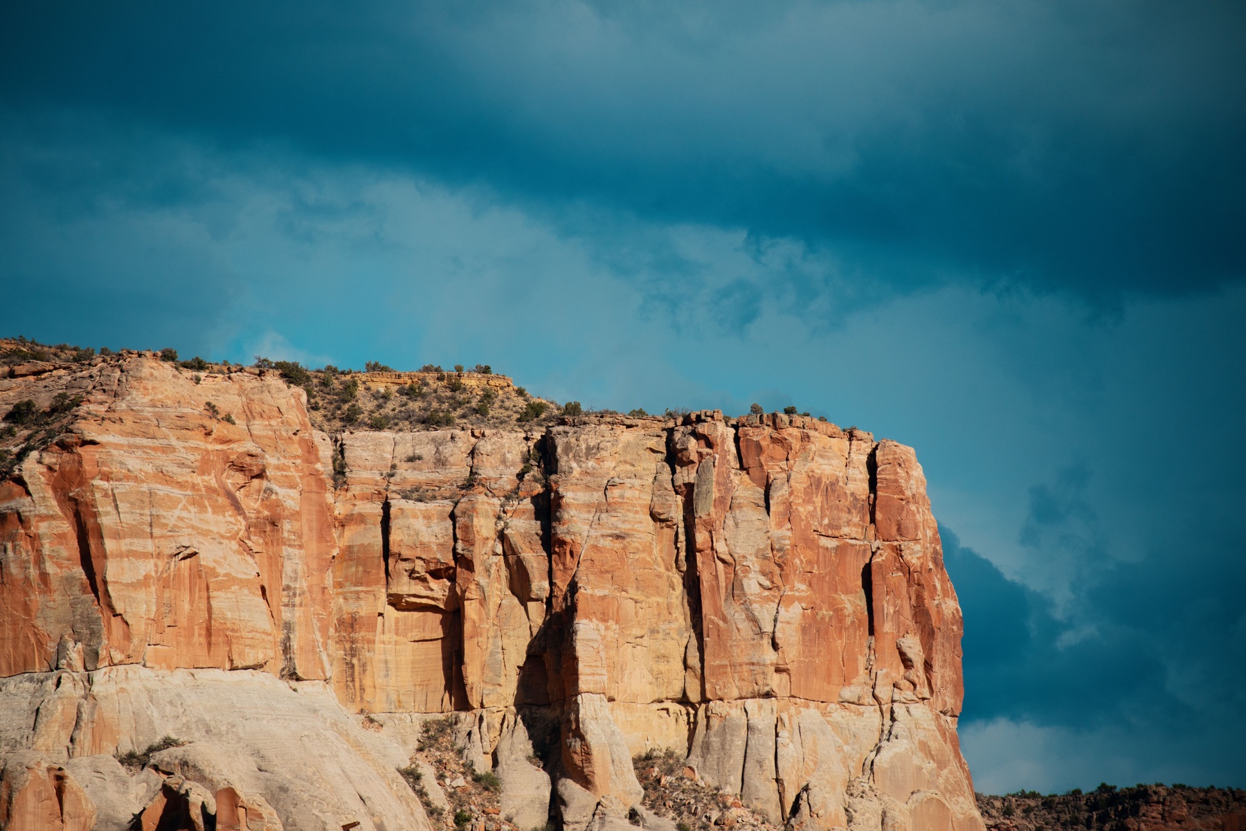 Layered desert cliffs beneath storm clouds