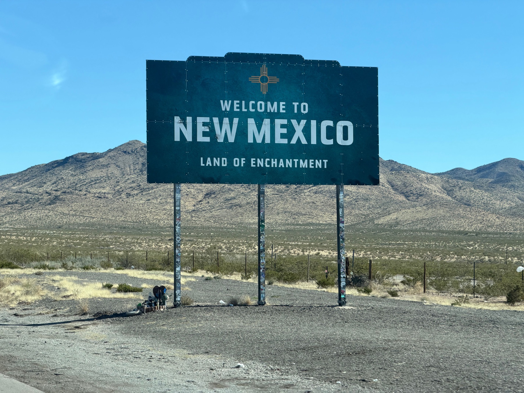 Welcome to New Mexico roadside sign in an open desert landscape